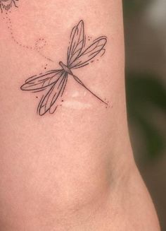 a black and white photo of a dragonfly tattoo