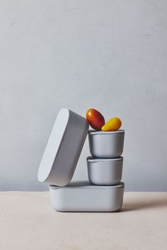 an assortment of bowls with fruit in them sitting on a counter top next to a wall