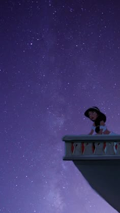 a woman sitting on top of a balcony under the stars