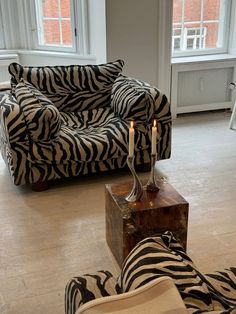 a living room with zebra print furniture and candles