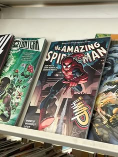 a row of comic books sitting on top of a book shelf