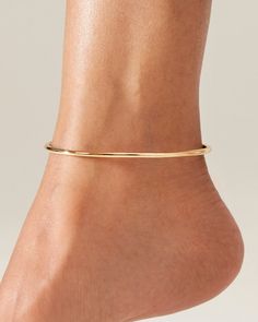 This anklet's water-durable, ultra-light steel makes for a statement-making piece. Dane is an oval shape and available in two sizes. The circumference measurement of the anklet is of 9 1/16th” or 10”. Make sure to add an extra ¾ inch minimum to allow for comfort. Dane is easy to put on and remove. To open, gently pull apart the anklet at the seam, rotating the tubes in opposite directions. Close by rotating back to the seam, and inserting the smaller tube into the opening. Finished in high-polis Adjustable Minimalist Anklets, Ankle Bangle, Tennis Anklet, Elegant Metal Anklets With Ankle Strap, Minimalist Gold Anklet With Adjustable Chain, Elegant Gold Metal Anklet, 14k Gold Ear Cuff, Elegant Anklet, Elegant Adjustable 14k Gold-filled Anklets