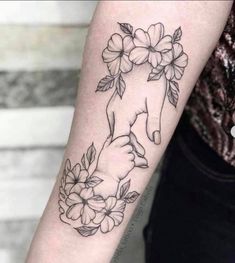 a woman's arm with flowers and a fox tattoo on the left inner arm