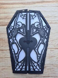 a paper cut out of a skeleton holding a heart with two skeletons on the side