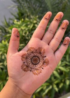 a person's hand with hendix on it and some plants in the background