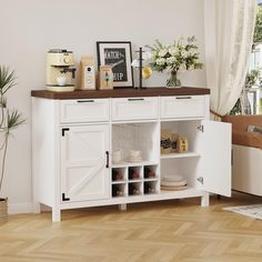 a white sideboard with open doors and shelves on it in a room next to a potted plant