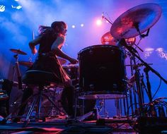 a woman playing drums on stage at a concert