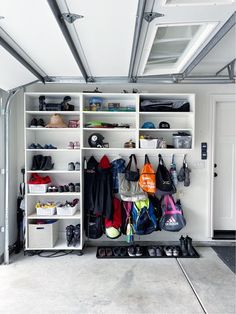 a white closet filled with lots of shoes and bags