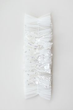 a white headband with sequins and beads on it, against a white background