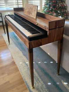 a piano sitting in front of a christmas tree