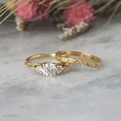 two gold wedding rings sitting on top of a table