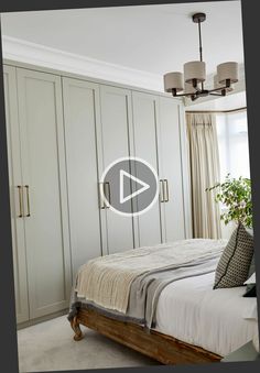 a bedroom with white cabinets and a large bed in the center, along with a potted plant