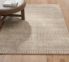 a living room area with wooden flooring and beige rug