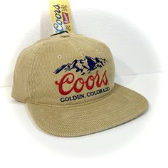 DETAILS: - Great-looking COORS BEER HAT for adults  - Tan with embroidered accents  - Officially licensed  - Unstructured crown with flat bill, retro 90s style   (new hat designed to look vintage) - Adjustable snapback - standard one size fits most adult  CONDITION: NEW WITH TAG   inventory ID#802401070TC2 Retro Adjustable Snapback Hat For Sports, Retro Flat Brim Snapback Hat For Baseball Season, Retro Flat Brim Hats For Baseball Season, Throwback Adjustable Flat Bill Hat, Vintage Snapback Hat For Baseball Season, Retro Snapback Fitted Hat With Embroidered Logo, Vintage Snapback Hat With Flat Bill For Streetwear, Retro Hat With Embroidered Logo For Baseball Season, Retro Embroidered Logo Snapback Hat For Streetwear