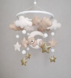 a crib mobile with stars, clouds and a teddy bear