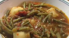 a white bowl filled with green beans and potatoes