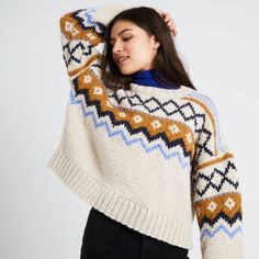 a woman is wearing a sweater with an ornament pattern