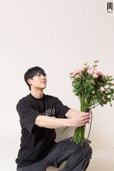 a man kneeling down with flowers in his hands