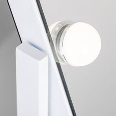 a close up of a light on the side of a mirror with an object in it