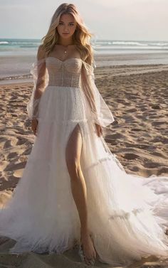 a woman standing on top of a sandy beach wearing a white dress and high heels