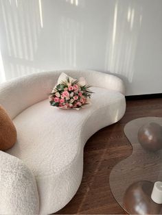 a teddy bear sitting on top of a white chair next to a vase filled with flowers