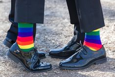 two people wearing rainbow socks and black shoes