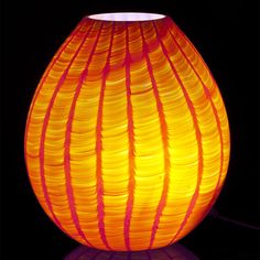 an orange and pink lamp on a black background