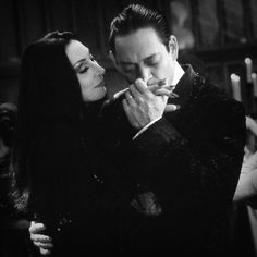 black and white photo of man and woman embracing each other with candles in the background