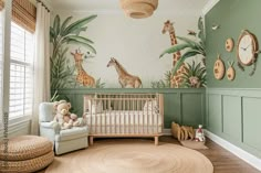 a baby's room with green walls and giraffes on the wall