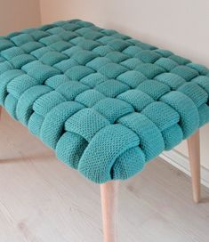 a blue bench with wooden legs in a room