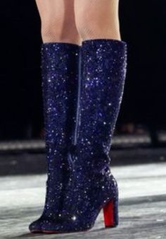 a woman's legs and boots on the runway