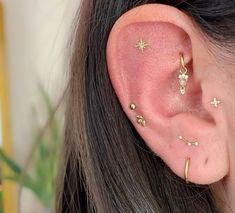 a close up of a person's ear with tiny gold stars on the side