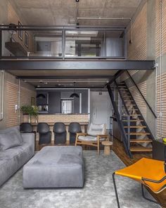 a living room filled with furniture next to a stair case in a loft style home