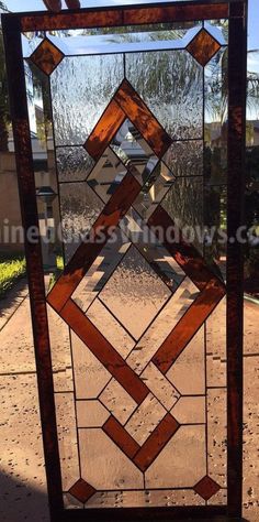 a stained glass window sitting on the side of a road in front of a house