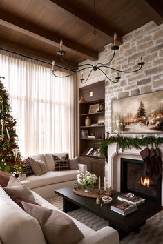 a living room filled with furniture and a christmas tree in front of a fire place