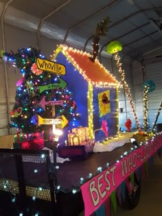 a house with christmas lights and decorations on the roof is decorated in pink, blue, green and yellow