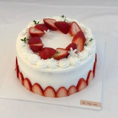 a cake with white frosting and strawberries on top