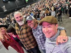 two men and a woman taking a selfie in front of an audience