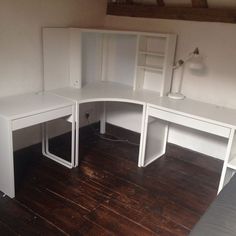 a corner desk with two white shelves on top