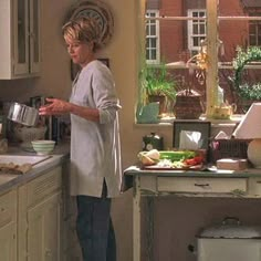 a woman standing in a kitchen preparing food