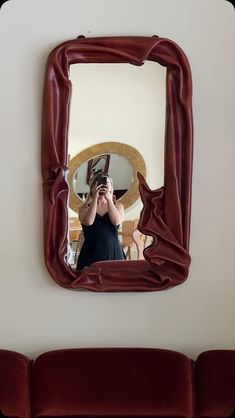 a woman taking a selfie in front of a mirror with her reflection on the wall