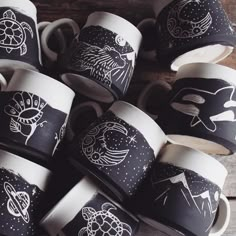 many cups with designs on them are stacked together