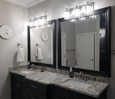 a bathroom with two sinks, mirrors and lights on the wall next to each other