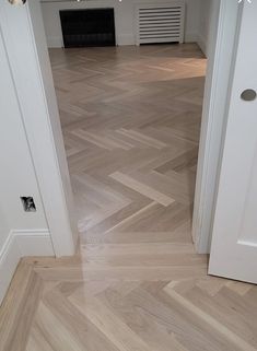 an open door leading into a room with wood flooring and white trimmings