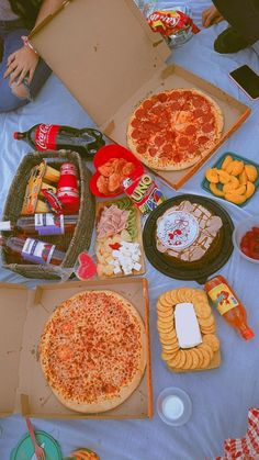 several pizzas and snacks on a table