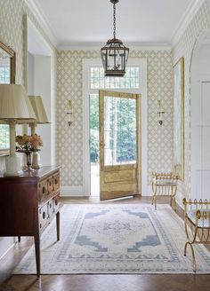 a room with a rug, chair, and lamp in front of a door that leads to another room