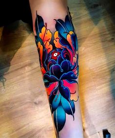 a woman's leg with colorful flowers on it and an eye in the center