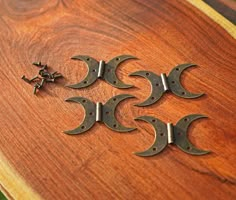 four pieces of metal sitting on top of a wooden table next to an arrow and star