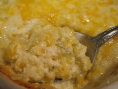 a close up of a spoon in a casserole dish with cheese and meat