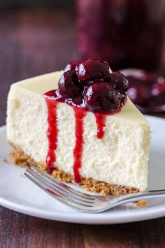 a piece of cheesecake with cherries on top is sitting on a white plate